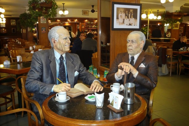 Borges and Bioy Casares (both writers)sitting at a table in a restaurant.