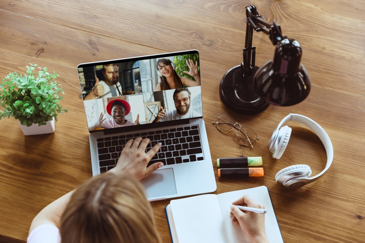 Remote meeting. Woman working from home during coronavirus or COVID-19 quarantine, remote office concept. a person sitting on a table