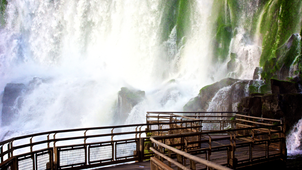 a waterfall with trees on the side of a fence